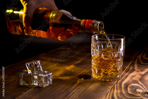 scottish whiskey and glass on wooden background