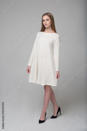 Young beautiful long-haired female model in white dress