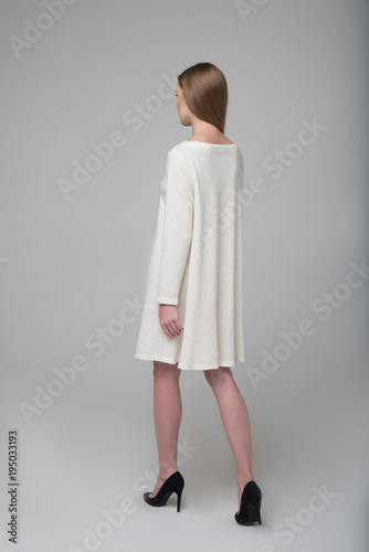 Young beautiful long-haired model girl in white dress