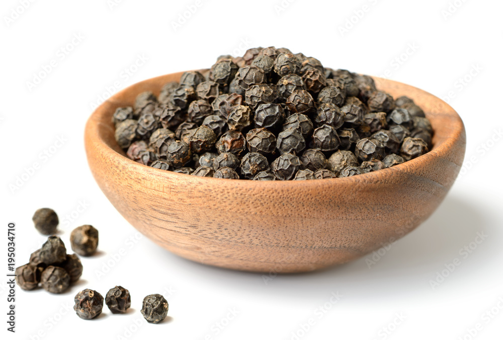 dried black peppercorns in the wooden plate, isolated on white dried black peppercorns in the wooden plate, isolated on white