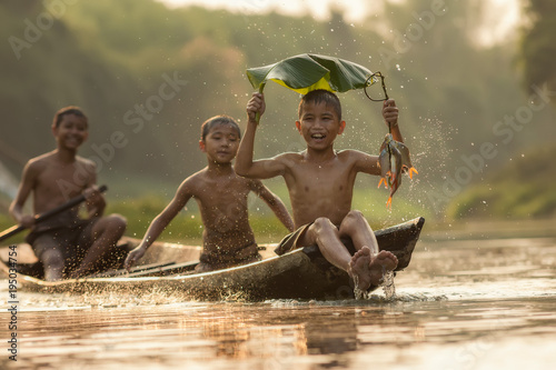 Asia children enjoying in boat on beautiful river
