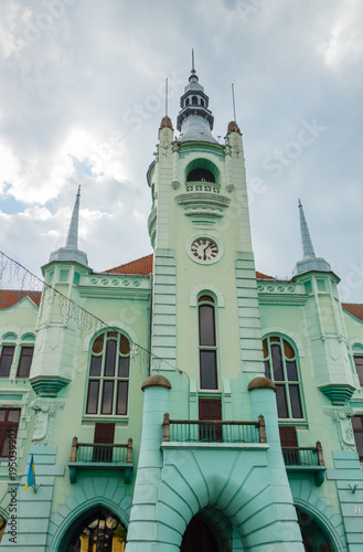 City hall of Mukacheve. Green colored building with cloudy sky background. photo