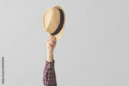 Person raised up hand holding hat photo
