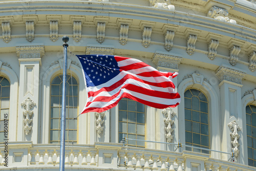 US National Flag in front of United State Capitol Building in Washington, District of Columbia, USA.
