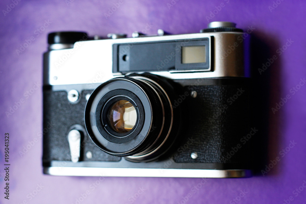 Retro film camera on purple background
