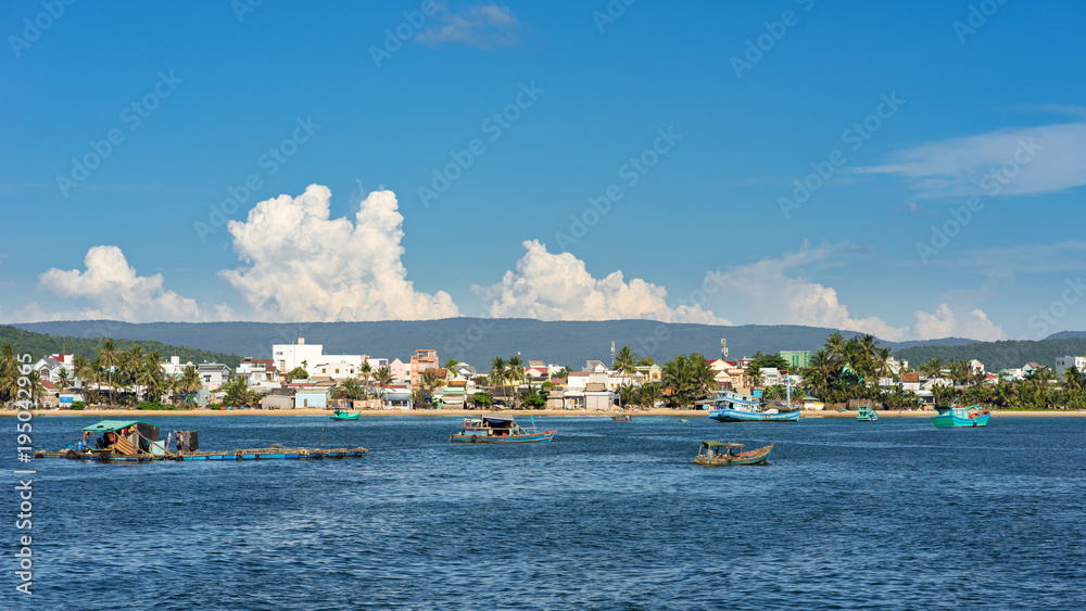 DUONG DONG, PHU QUOC, VIETNAM - NOVEMBER 16, 2017: View on Duong Dong  coastline from the sea. Local fishing boats and ships in water near coast