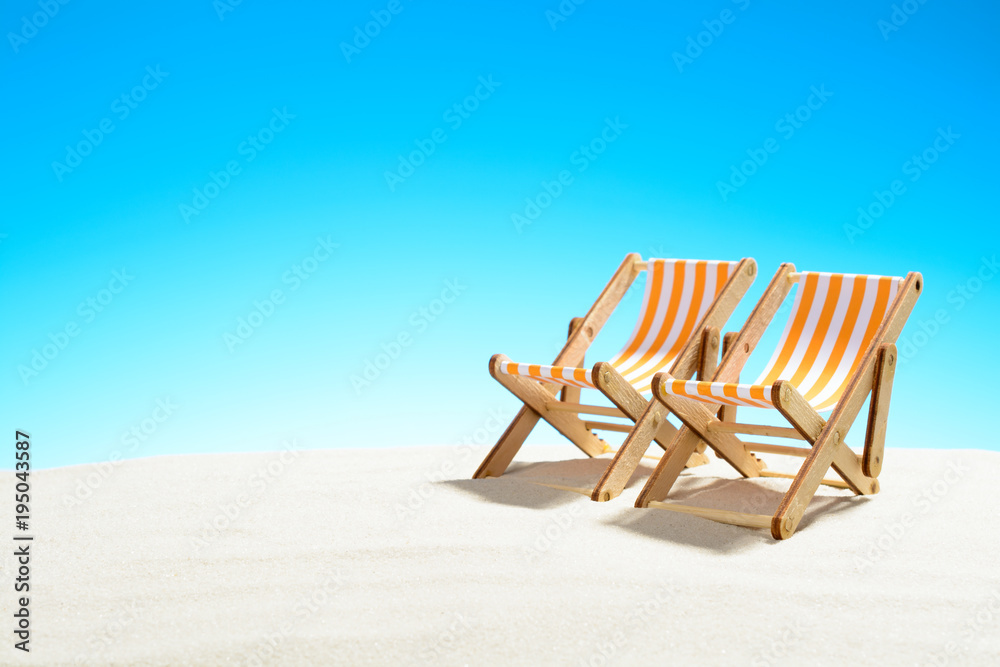 Two sun loungers on the sandy beach and the sky with copy space Two sun loungers on the sandy beach and the sky with copy space