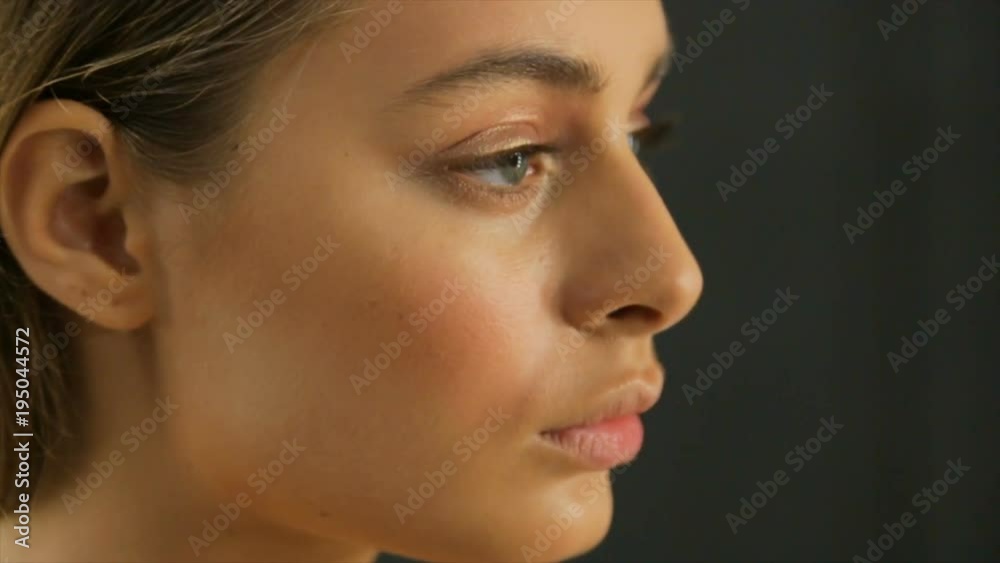 Beautiful model applying eyeliner closeup on eye, Close up, Make-up artist applying bright base color eyeshadow on model's eye and holding a shell with eyeshadow Beautiful model applying eyeliner closeup on eye, Close up, Make-up artist applying bright base color eyeshadow on model's eye and holding a shell with eyeshadow