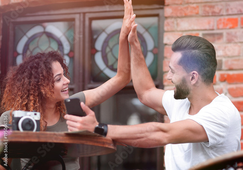 Portrait of a young  couple sitting down at a cafe terrace