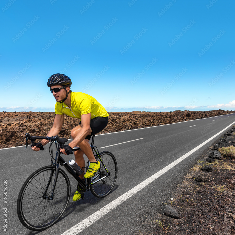 Fototapeta premium Road biking cyclist man training on bike professional cycling athlete riding racing bicycle in competition race on open road biking with high intensity on highway on workout for triathlon.