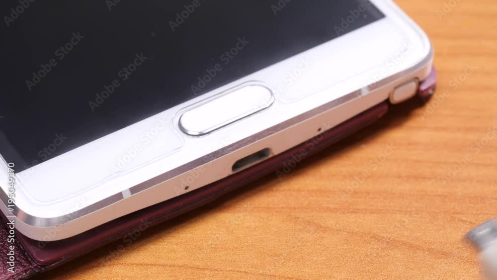 Close up mobile phone charging, male hand disconnecting unplug cable from smartphone Close up mobile phone charging, male hand disconnecting unplug cable from smartphone