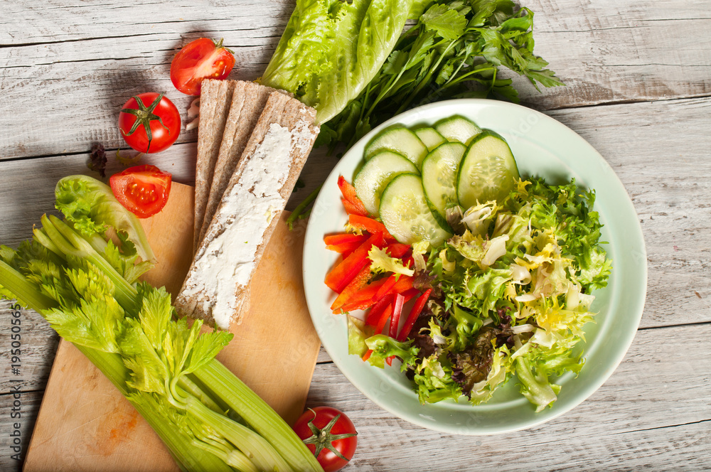 salad from raw vegetables and a sandwich with soft cheese and wheat loaves. The concept of a healthy diet or vegetarianism. salad from raw vegetables and a sandwich with soft cheese and wheat loaves. The concept of a healthy diet or vegetarianism.