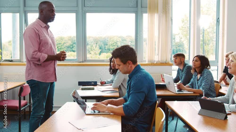 Male Tutor Standing To Teach Class Of Mature Students Male Tutor Standing To Teach Class Of Mature Students