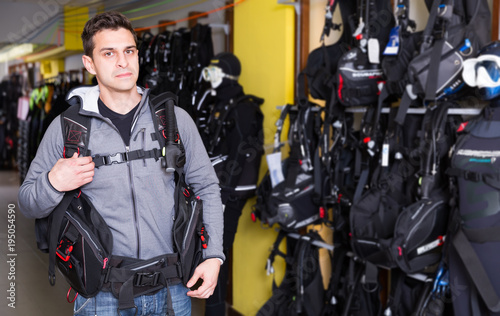 Active young man standing in new diving equipment