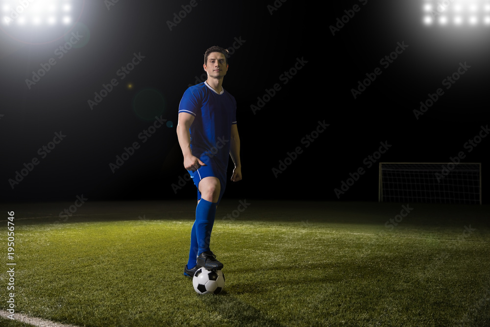 Footballer with ball on soccer field
