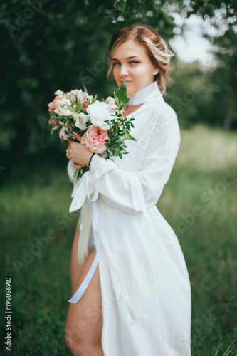stylish wedding bride with bouquet and amazing modern dress. bride posing and smiling in sunny garden © Dmitriy Shipilov