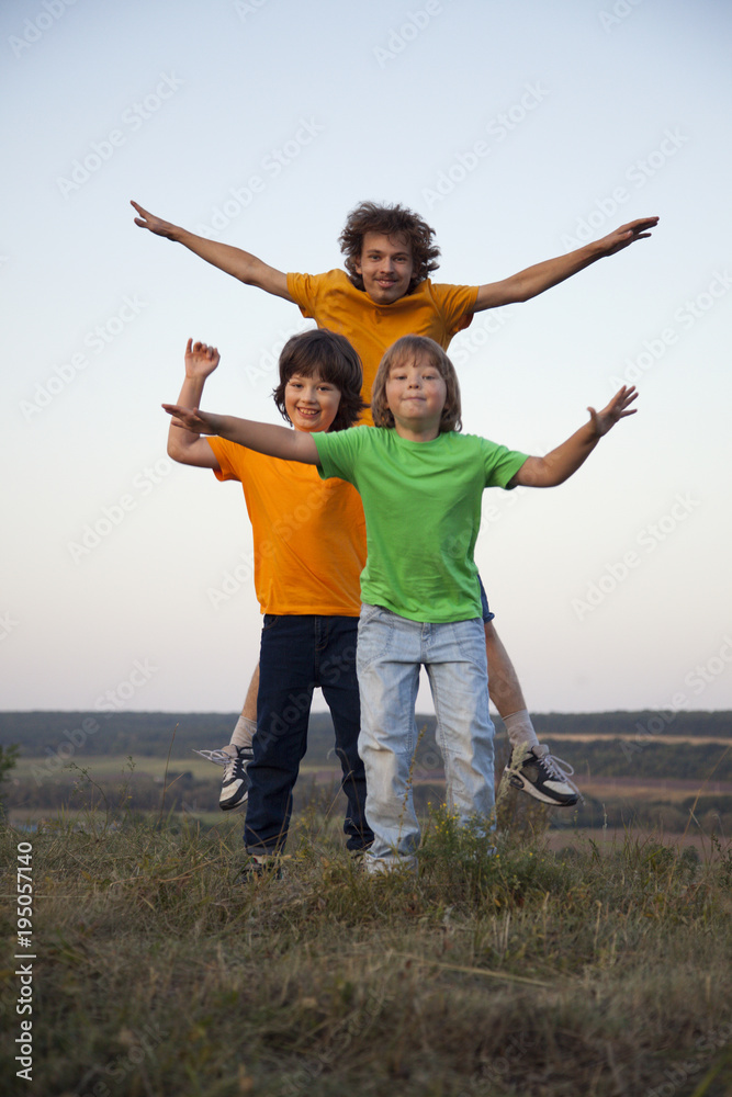 Children playing jumping on summer sunset meadow silhouetted Children playing jumping on summer sunset meadow silhouetted
