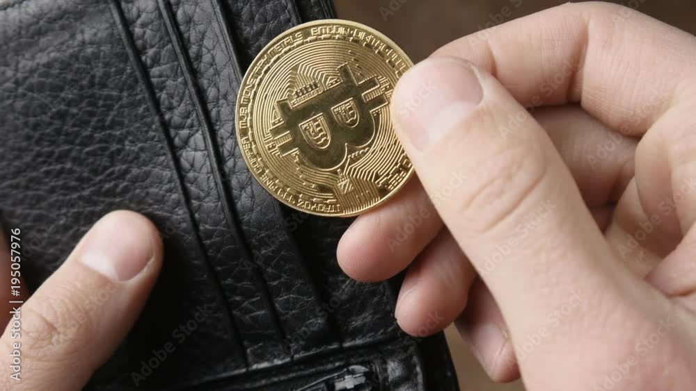 Male hand holding bitcoin and putting it in his wallet. Concept of earning crypto currency. Mining bitcoin. Male hand holding bitcoin and putting it in his wallet. Concept of earning crypto currency. Mining bitcoin.
