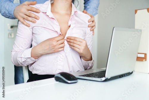 Sexual flirt at work. Secretary's unbuttons her blouse. photo