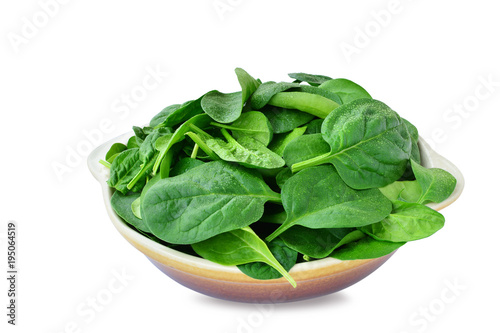 Baby spinach leaves in stoneware bowl isolated on white background