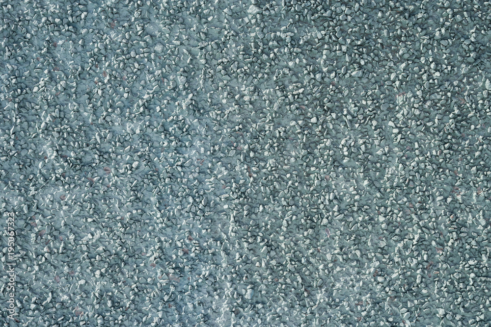 The texture of the plastered surface with a fine gravel of gray color.