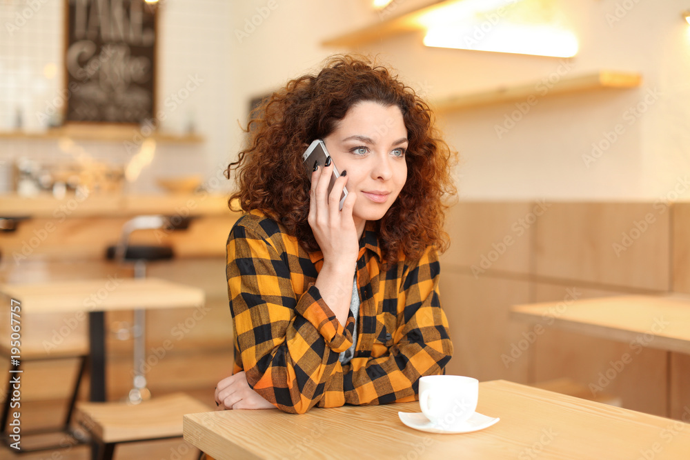 Young woman talking on mobile phone indoors Young woman talking on mobile phone indoors