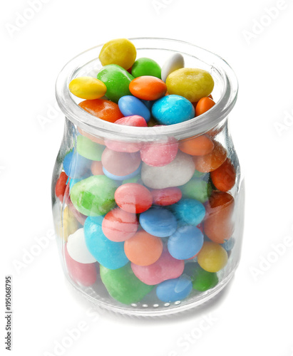 Glass jar with colorful candies on white background
