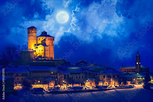 Serralunga castle during a cold winter night with snow in langhe region, Italy photo