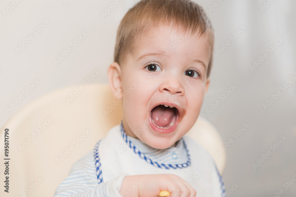 baby in the kitchen eating fruit puree baby in the kitchen eating fruit puree