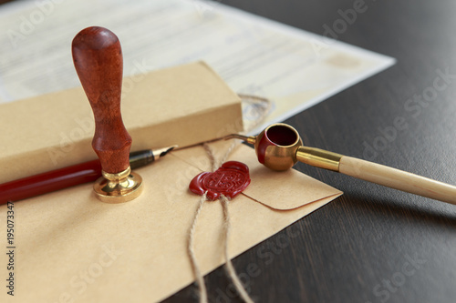 Fountain pen and old notarial wax seal on document, closeup