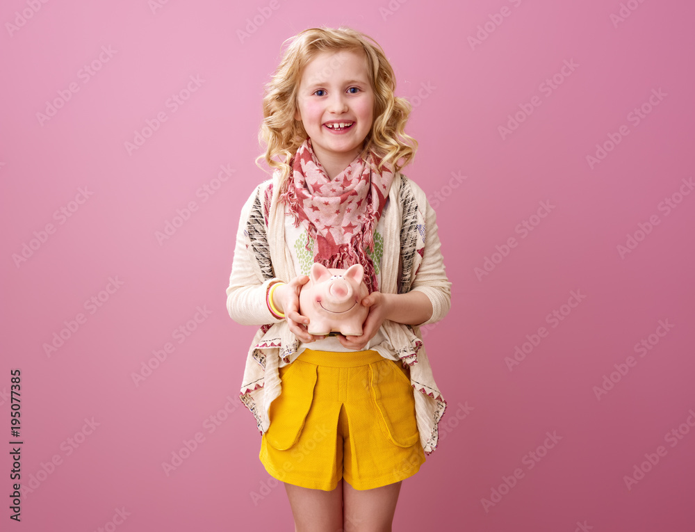 happy modern child isolated on pink showing piggy bank happy modern child isolated on pink showing piggy bank