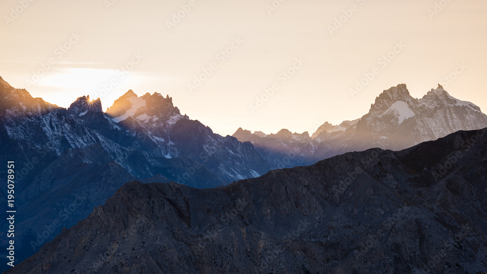High altitude alpine landscape at dawn with first light glowing the majestic high peak of the Barre des Ecrins (4101 m), France.