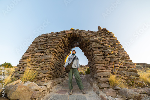Tourist exploring Inca trails at sunset on Amantani' Island, Titicaca Lake, among the most scenic travel destination in Peru. Travel adventures and vacations in the Americas. photo
