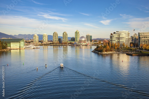 Boats and paddleboarders in False Creek, Vancouver with views of Science World and Olympic Village photo