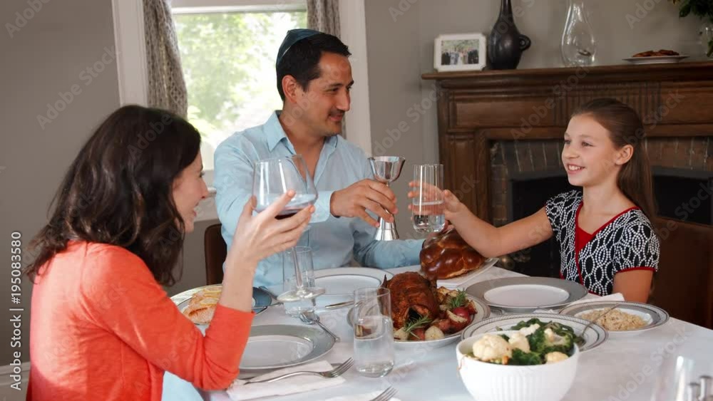 Jewish family making a toast before their Shabbat meal Jewish family making a toast before their Shabbat meal