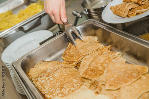 a lot of pancakes with different fillings on a baking sheet. photo