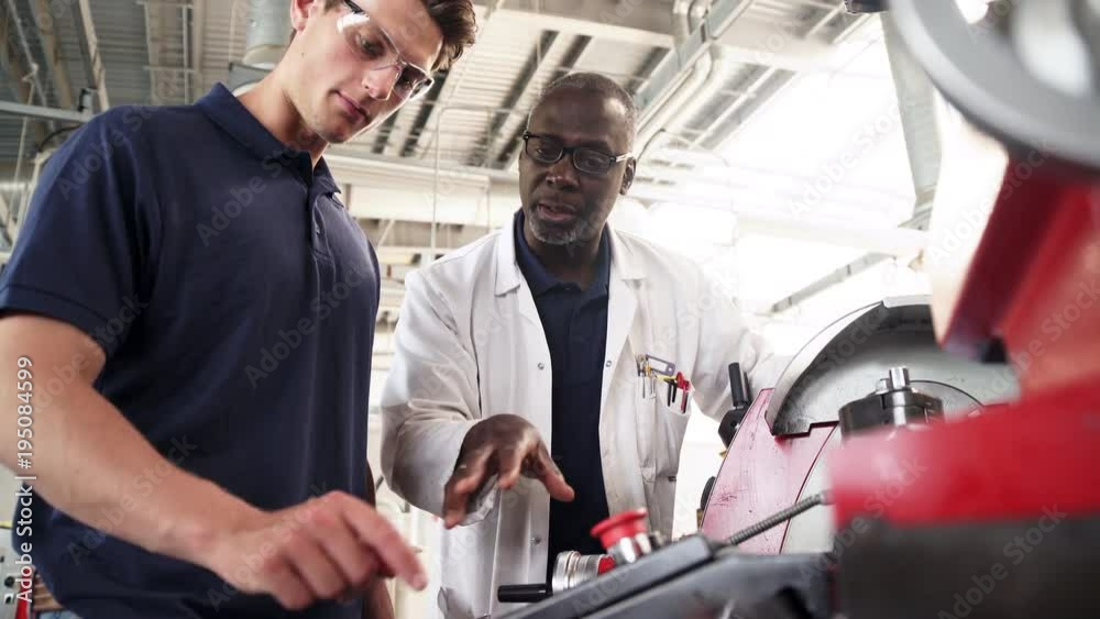Engineer Teaching Apprentice How To Use Machine In Factory Engineer Teaching Apprentice How To Use Machine In Factory