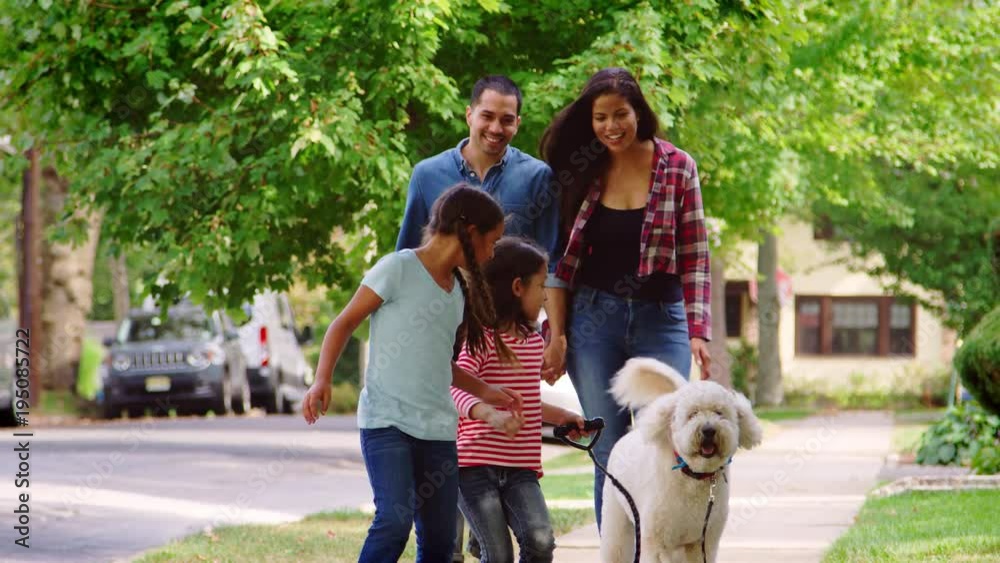 Family Walking Dog Along Suburban Street