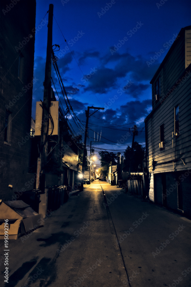 Dark city alley during sunset with dramatic sky and clouds