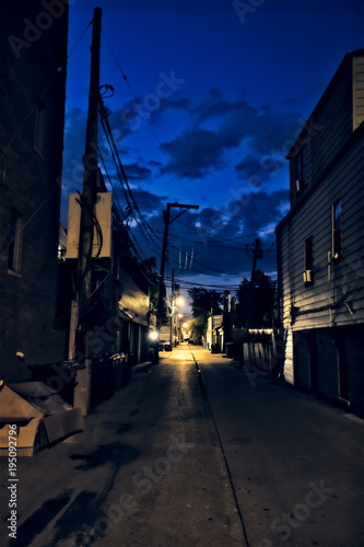 Dark city alley during sunset with dramatic sky and clouds