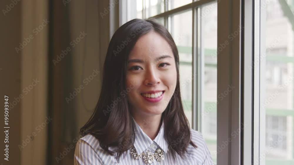 Casually dressed Asian businesswoman smiling to camera Casually dressed Asian businesswoman smiling to camera