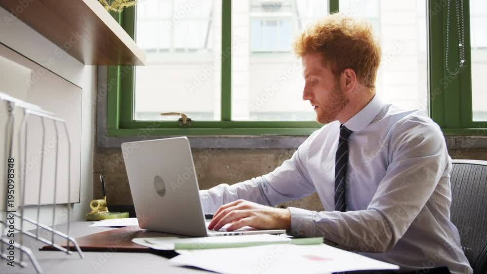 Red haired businessman working with laptop, close up Red haired businessman working with laptop, close up
