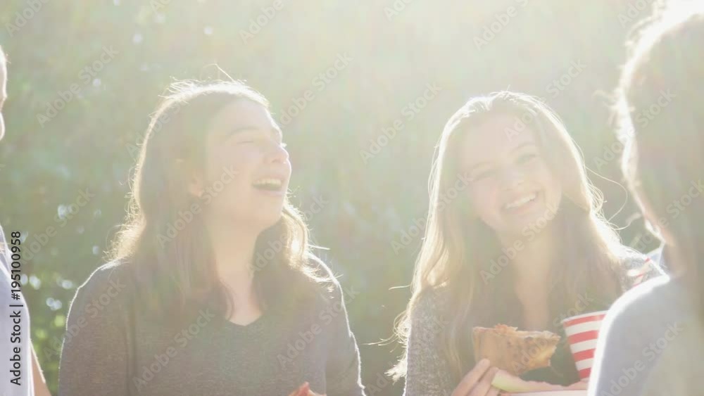 Teen girls eating and talking at a neighbourhood block party