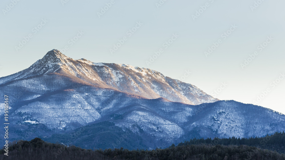 Snowy peak mountain on a blue sky on a dawn nature landscape