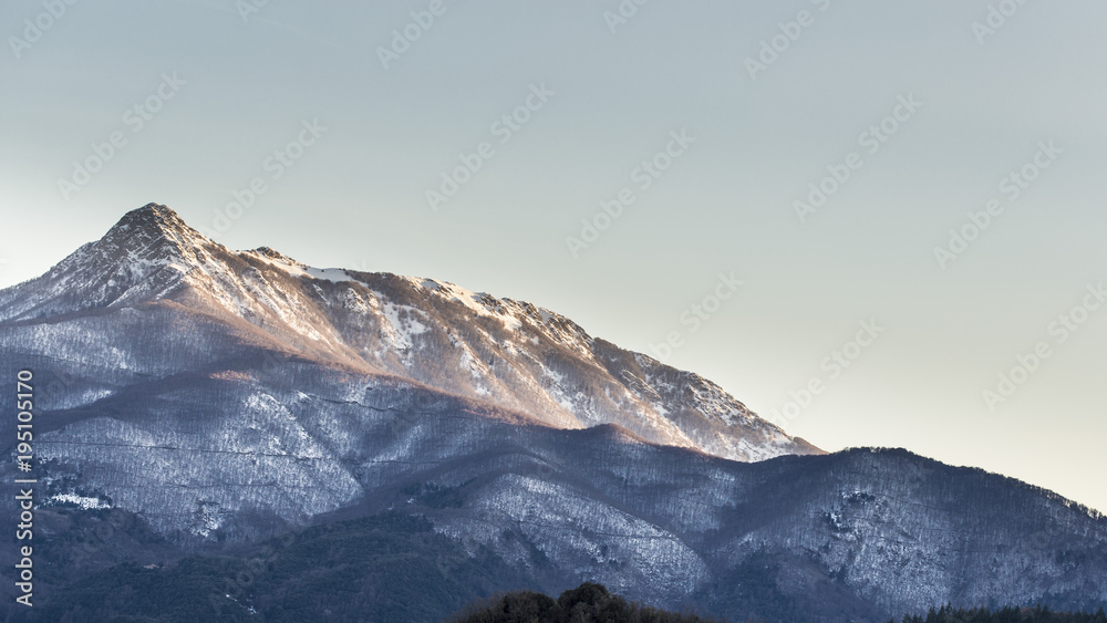 Snowy peak mountain on a blue sky on a dawn nature landscape