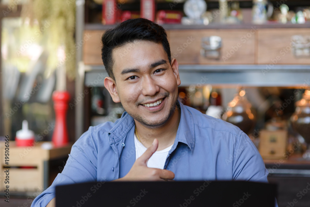 Fototapeta premium Thumb up Asian man working with laptop in cafe, work concept.