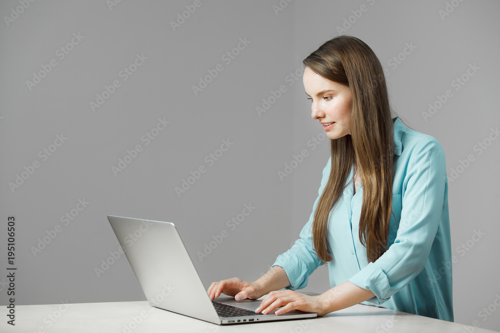 Young woman sits at laptop involved in work Young woman sits at laptop involved in work