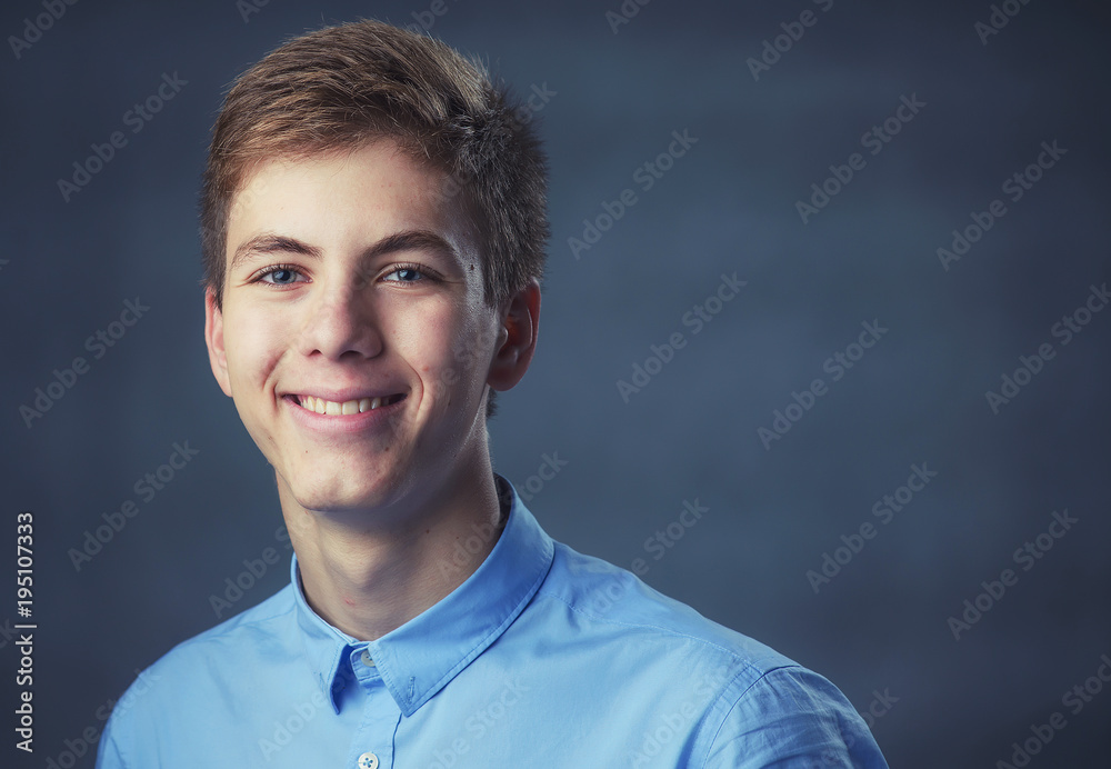Obraz premium young man on grey background, student in blue shirt