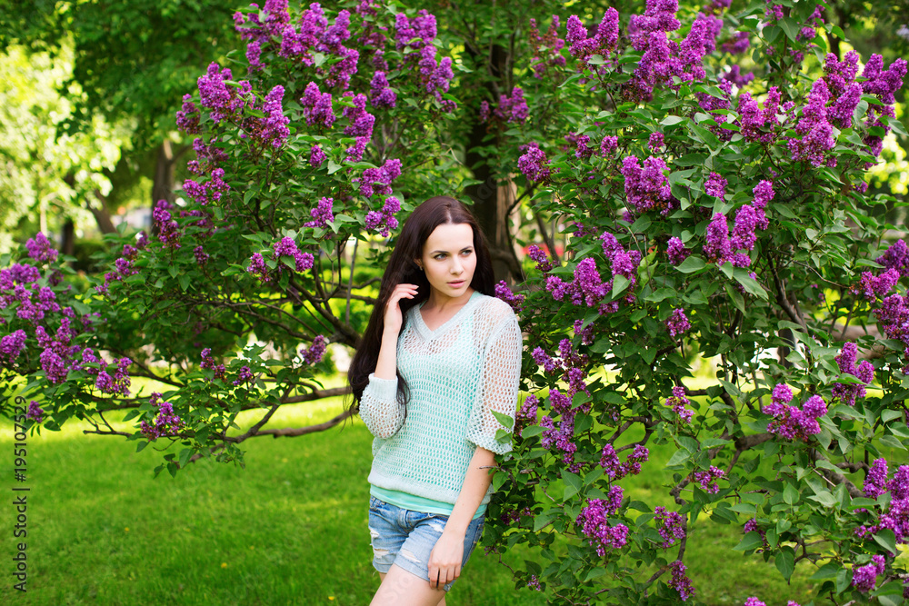 Attractive girl in the park against a flowering tree. Attractive girl in the park against a flowering tree.