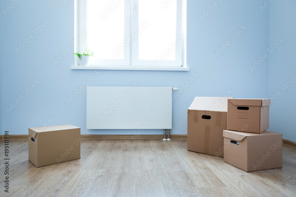 Cardboard boxes on laminate floor in empty room Cardboard boxes on laminate floor in empty room